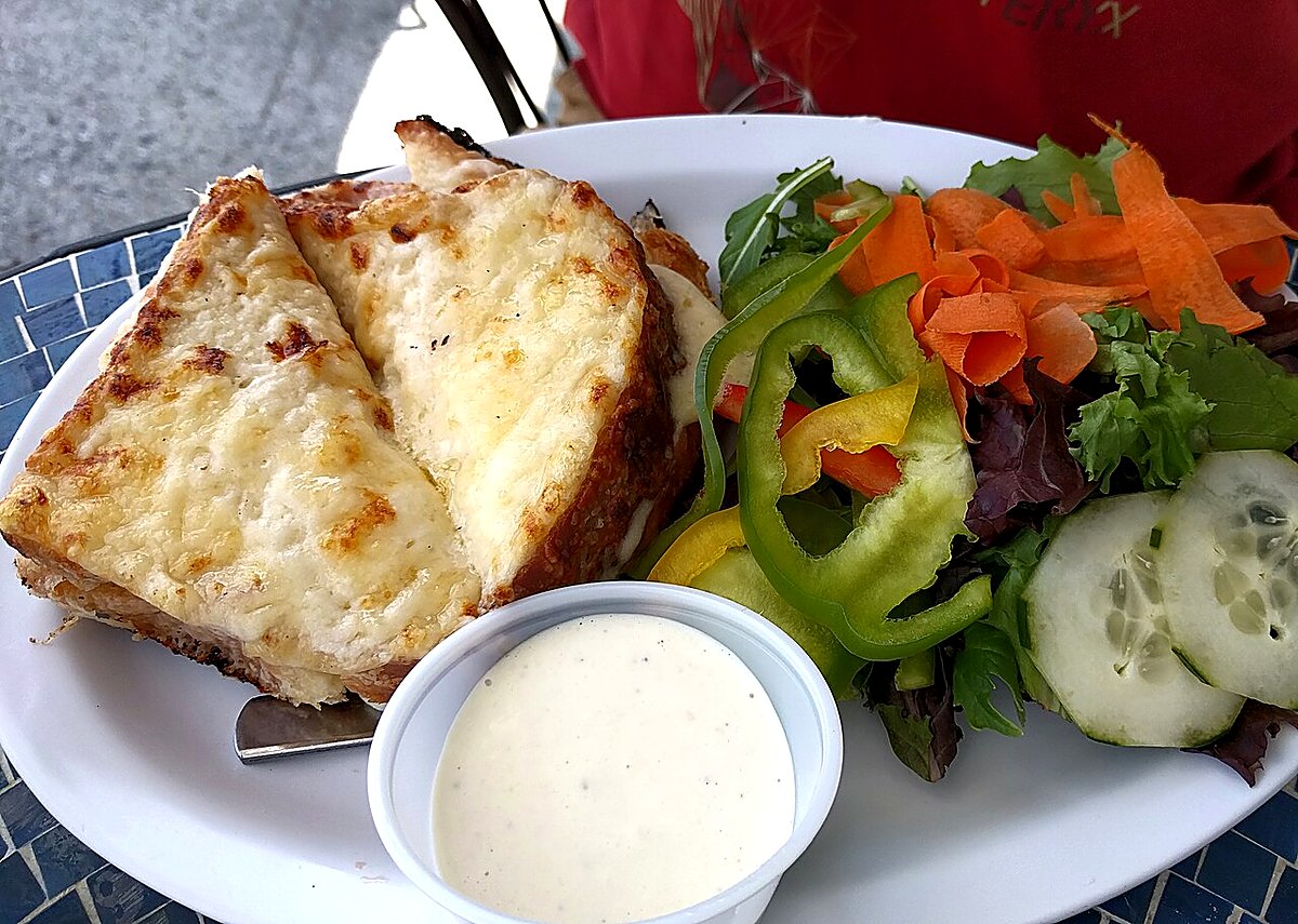 A bronzed croque monsieur with green salad