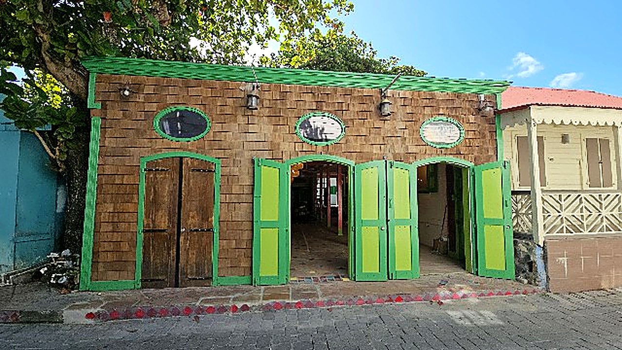 La Sucriere storefront with green doors under a tree