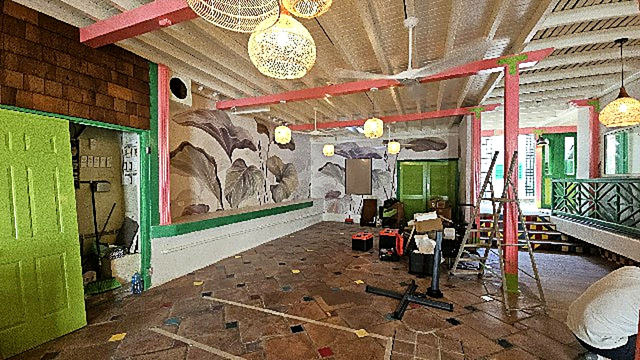 Inside the new maison — rose and green painted beams, rattan pendant lights and a banana-leaf mural