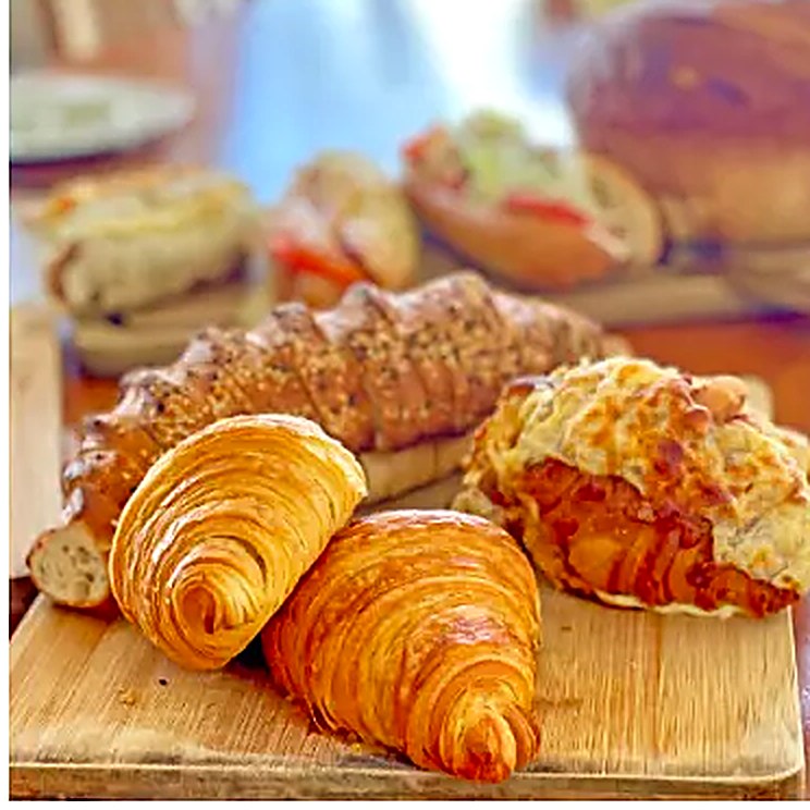 Fresh-baked butter croissants on a wooden board at La Sucrière boulangerie