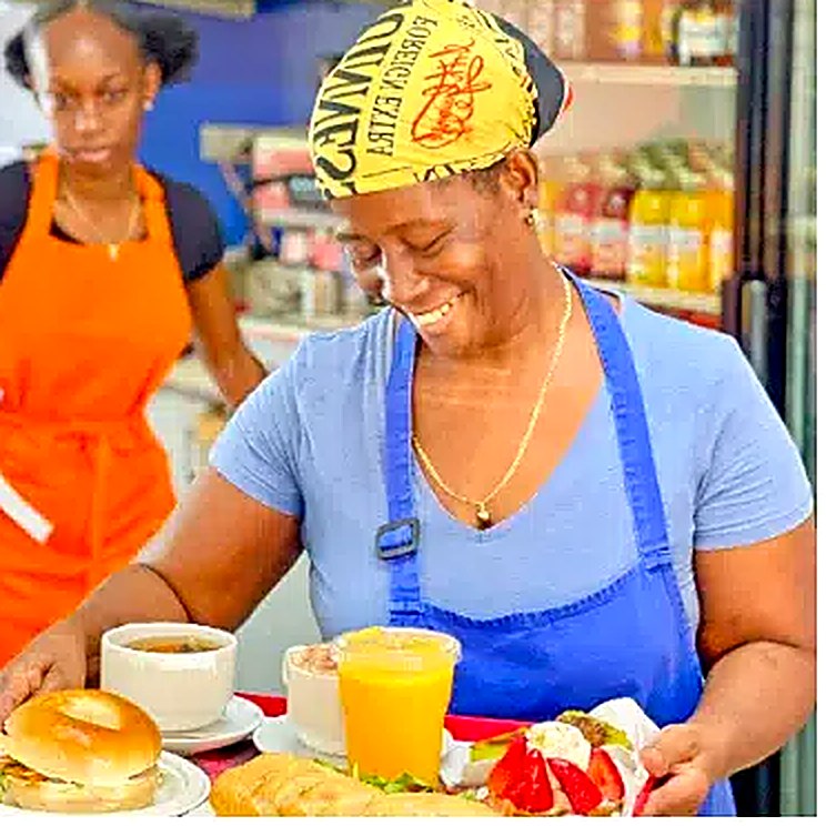 A smiling member of the La Sucrière team welcoming guests at the bakery counter