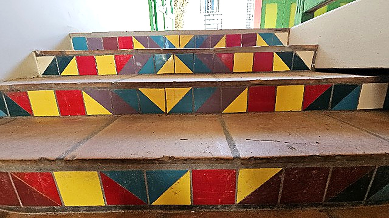 Hand-laid steps in red, yellow and teal triangle tiles at the Philipsburg maison